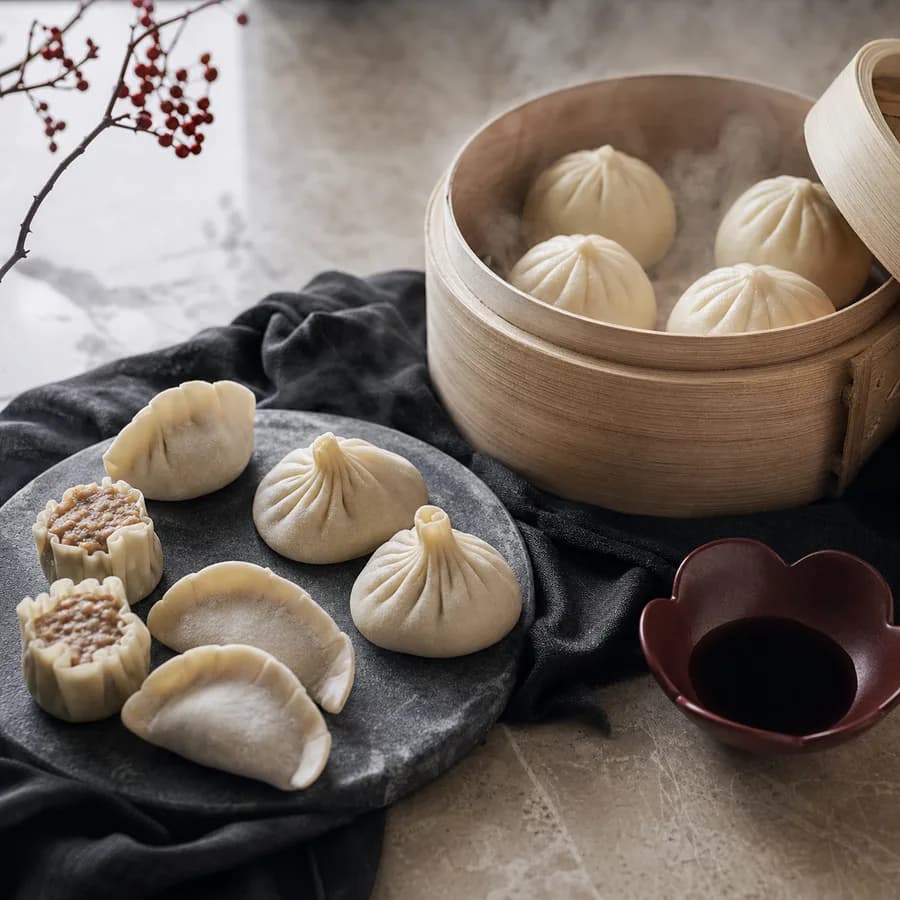 Ångade dumplings och dim sum i bambukorg